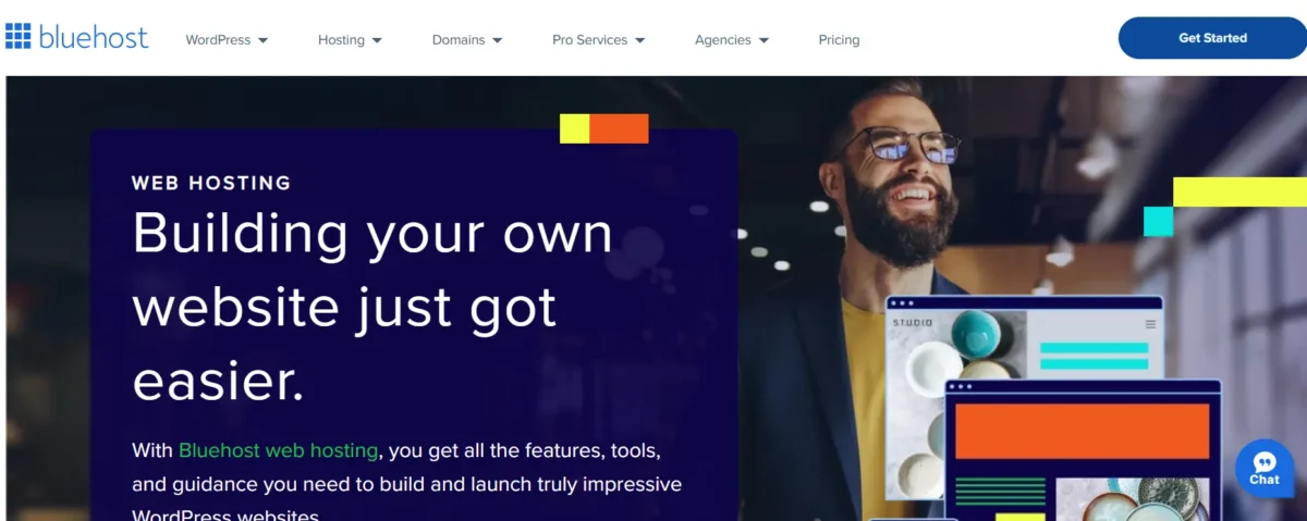 Man smiling next to screens showing website designs – Bluehost hosting made simple.